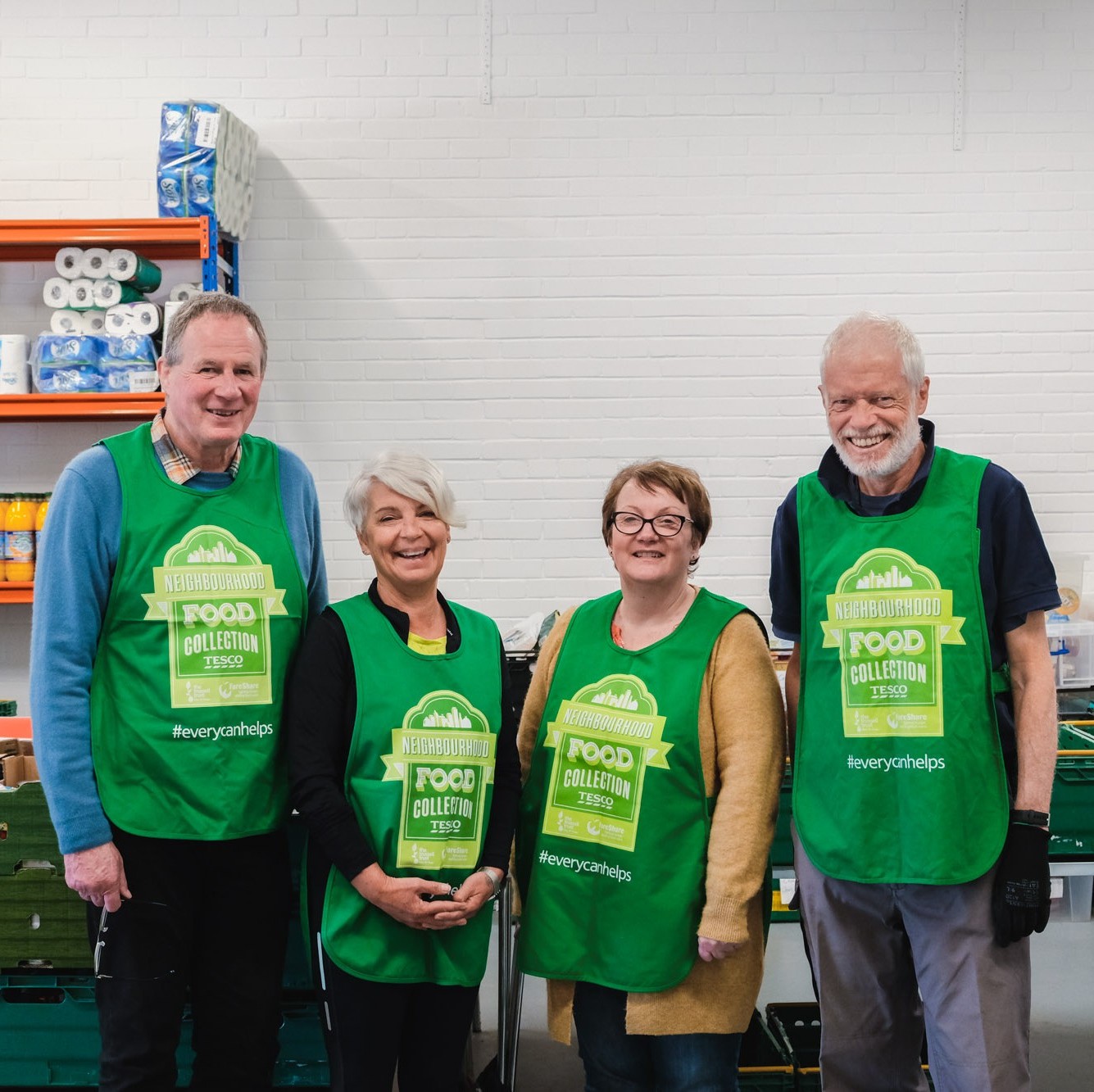 4 volunteers at Edinburgh NE Foodbank stand together smiling.